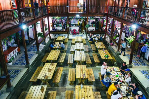 Vibrant dining spaces with wooden tables and colorful decor in Recinto Gastronómico, Salento, Quindío, Colombia.