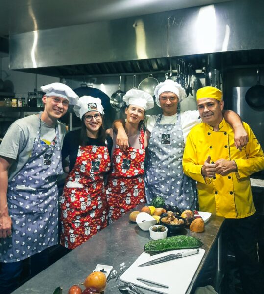 Cooking class participants wearing colorful aprons in a vibrant kitchen in Salento, Quindio, Colombia, ready to prepare meals.