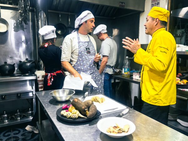 Participants engage in a vibrant cooking class, preparing local dishes in a well-equipped kitchen in Salento, Quindio, Colombia.