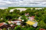 Vibrant rooftops and lush greenery overlook the vast Amazon River, showcasing the natural beauty of Puerto Nariño, Amazonas, Colombia.