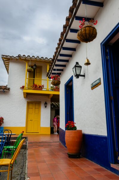 Colorful colonial architecture at Pueblito Paisa in Medellín, featuring vibrant flowers, a charming courtyard, and traditional tiles.