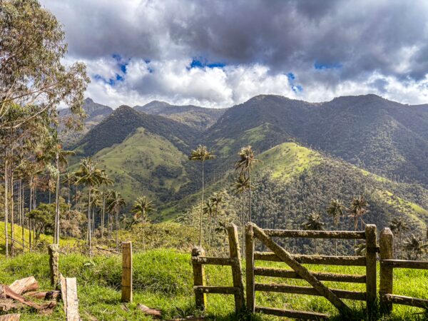Lush green hills and dramatic clouds frame Carbonera Valley in Quindío, Colombia, highlighting the region's natural beauty.