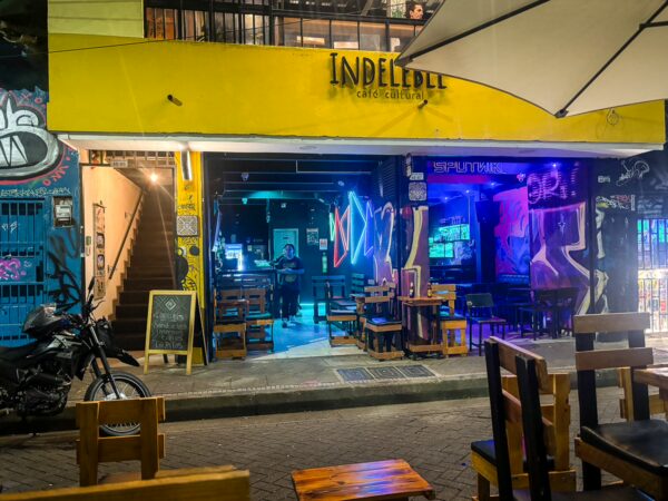Indeleble bar in Medellín features vibrant colors, outdoor seating, and artistic graffiti, creating a lively atmosphere.