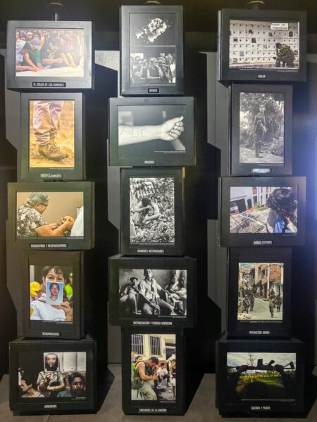 A display of black photo frames showcasing powerful images related to history and culture at Museo Casa de la Memoria in Medellín.
