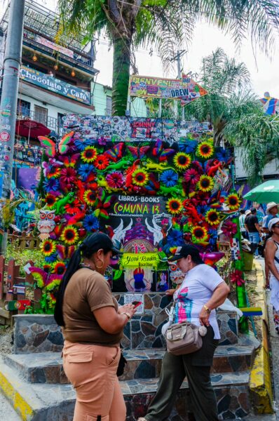 Vibrant floral decorations adorn a staircase in Comuna 13, Medellín, showcasing local art and community spirit.