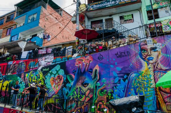 Vibrant street art adorns the walls of Comuna 13 in Medellín, featuring colorful murals and lively community life.