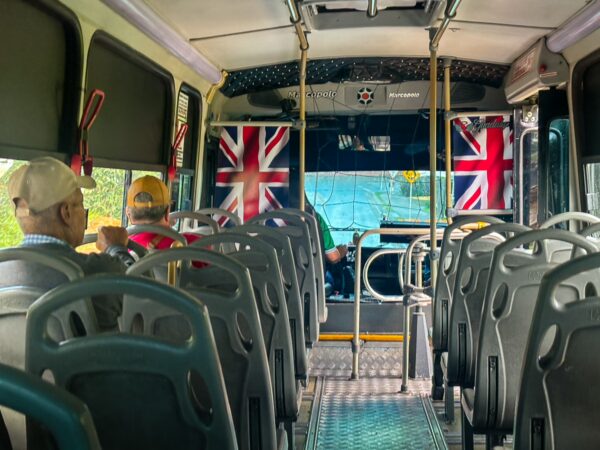 Colorful interior of a bus in Arvi Park, Medellin, featuring Union Jack flags and several passengers enjoying their ride.