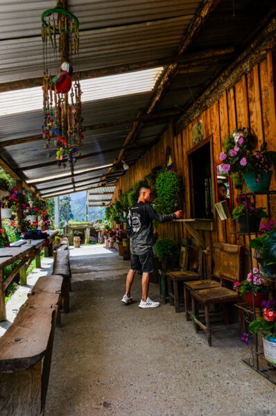 El Gallego restaurant features a rustic wooden interior adorned with vibrant flowers, set in Carbonera Valley, Quindio, Colombia.