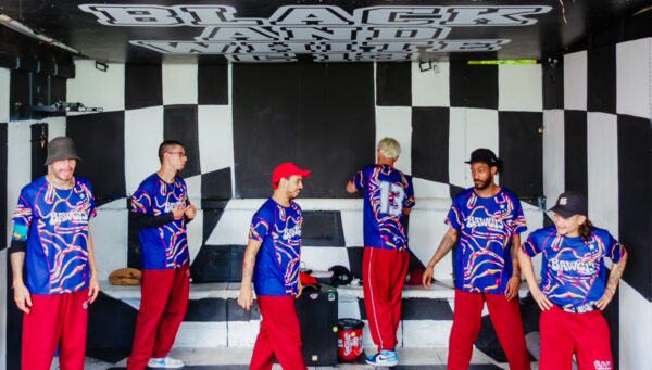 Group of dancers in colorful jerseys rehearsing in a vibrant black and white patterned room in Comuna 13, Medellín.