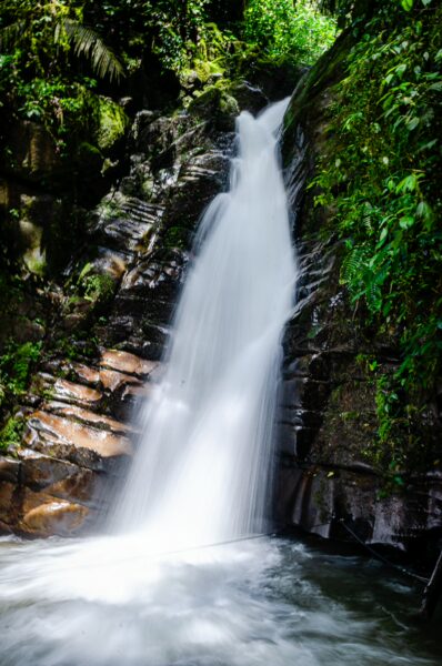 Majestic Santa Rita Waterfalls cascade down rocky cliffs, surrounded by lush greenery in Salento, Quindio, Colombia.