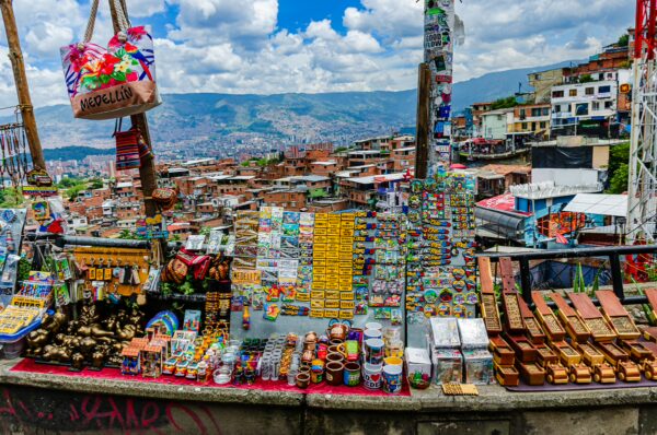 Vibrant market stalls filled with colorful crafts and snacks overlook the hillside of Comuna 13 in Medellín, Colombia.