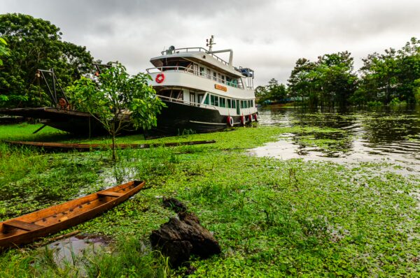 Boat docked among lush greenery and reflecting waters in Leticia, Amazonas, Colombia, showcasing the serene Amazon landscape.