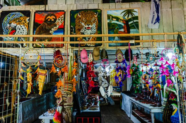 Vibrant crafts and art displayed in a market in Puerto Nariño, Amazonas, Colombia, with colorful wildlife paintings and local souvenirs.