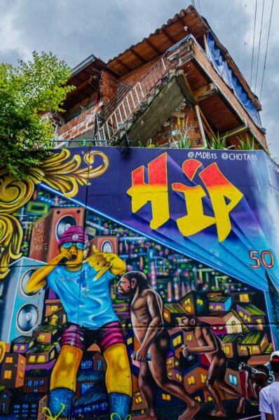Colorful street art featuring a vibrant mural in Comuna 13, Medellín, showcasing music and urban life with lively characters.