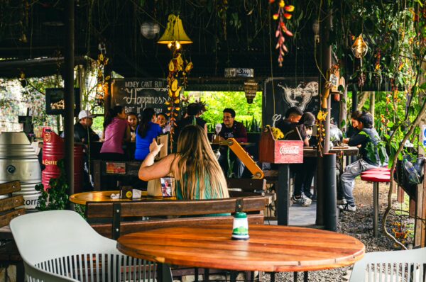Vibrant scene at Santa Rita Waterfalls featuring patrons enjoying drinks and lively decor in Salento, Quindío, Colombia.