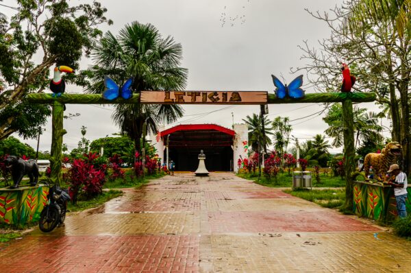 Colorful entrance archway featuring butterflies and birds, leading into Parque Orellana in Leticia, Amazonas, Colombia.