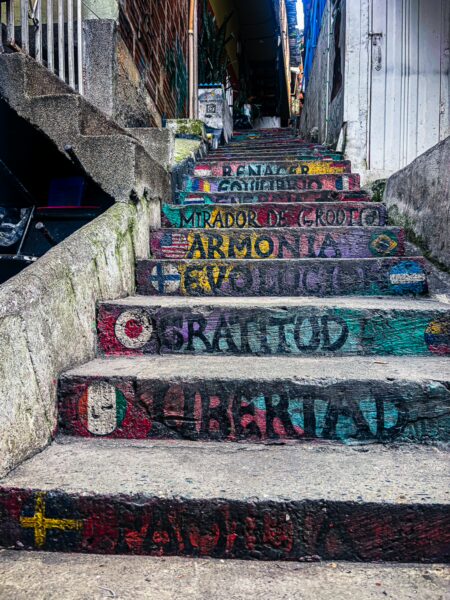 Colorful graffiti decorates the steps in Comuna 13, showcasing vibrant art and messages in Medellín, Antioquia.