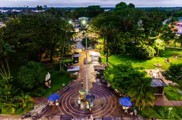 Lush greenery and pathways at Parque Santander in Leticia, Amazonas, Colombia, with benches and shaded areas for relaxation.