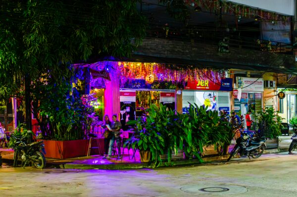 Vibrantly lit restaurant with lush green plants at night in Leticia, Amazonas, Colombia, showcasing a lively local atmosphere.