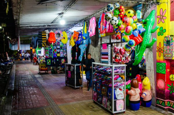 Vibrant street market in Leticia, Amazonas, Colombia, featuring colorful stalls with toys, crafts, and lively decorations.