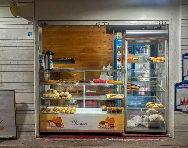 Bucaramanga's bakery display features a variety of pastries and breads, showcasing warm colors and fresh goods behind glass.