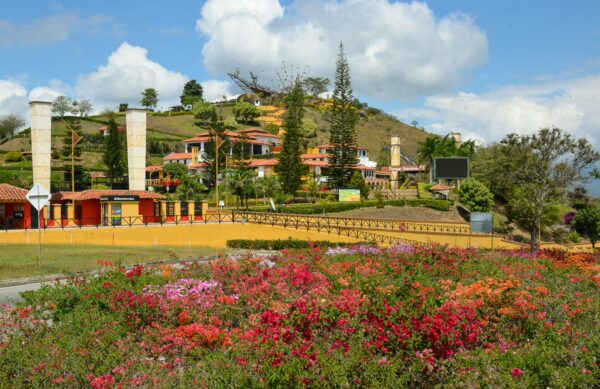 Chicamocha National Park station on a hillside with flower beds, red-roofed buildings, and a cable car structure against the sky