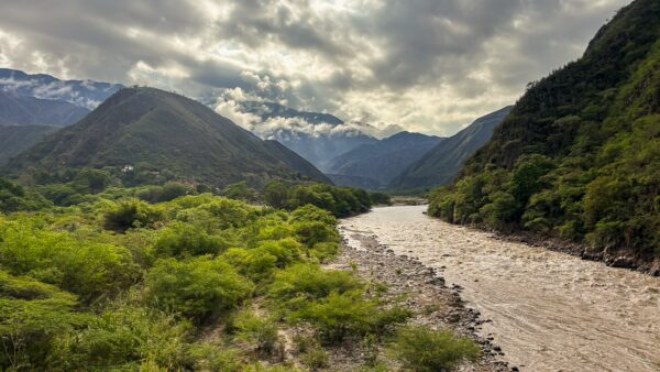 River winding through Chicamocha Canyon between steep green slopes and cloudy mountains