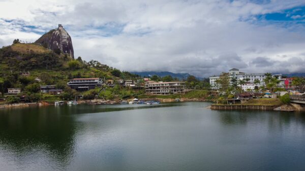 El Peñón de Guatapé rises above the reservoir near Guatapé, Colombia, with hills and waterfront buildings in the foreground