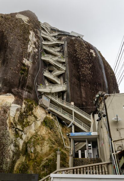 El Peñol Rock in Guatapé, Antioquia, Colombia, features a towering granite formation with a staircase leading to its summit.