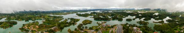 Spectacular aerial view of Guatapé, Antioquia, Colombia, showcasing lush greenery and winding waterways under a cloudy sky.