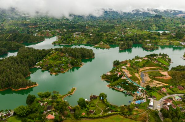 Stunning aerial view from El Peñol Rock in Guatapé, Antioquia, Colombia, featuring vibrant green hills and reflective blue waters.