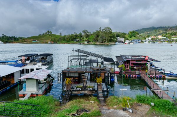 Floating bars and boats on the Guatapé waterfront overlooking the reservoir and green hills