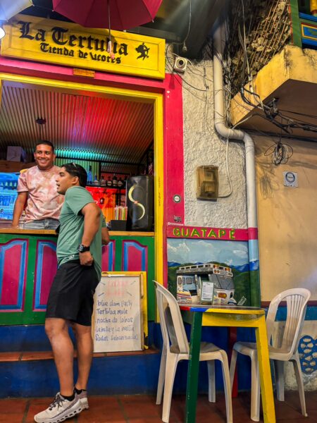 Brightly colored storefront of La Territula in Guatapé, featuring cheerful seating and a friendly atmosphere.