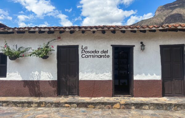 La Posada del Caminante in Santander, Colombia, showcases a charming white facade with brown accents and vibrant green plants.