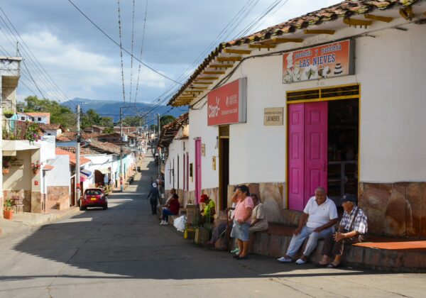 Street in Los Santos, Santander, with people sitting outside a bakery and pastel shop on Mesa Los Santos