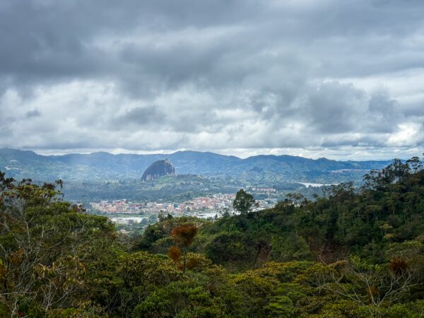 Panoramic view from Mirador San José in Guatapé, Antioquia, Colombia, showcasing lush greenery and distant mountains under a cloudy sky.