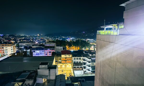 Vibrant cityscape of Ibagué at night, showcasing illuminated buildings and rooftops with a serene atmosphere.