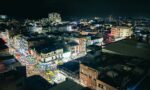 Vibrant night view of Ibague, Tolima, showcasing bustling streets illuminated by city lights and lively storefronts.