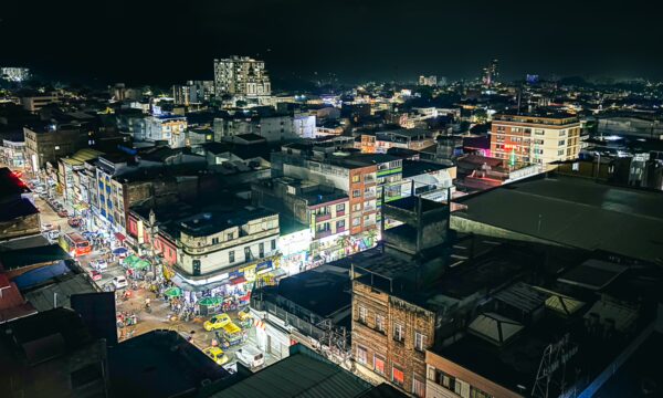 Vibrant night view of Ibague, Tolima, showcasing bustling streets illuminated by city lights and lively storefronts.