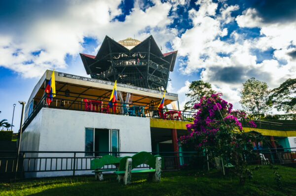 Vibrant flowers and colorful flags adorn the Mirador Colina Iluminada, showcasing its unique architectural design in Filandia, Quindío.