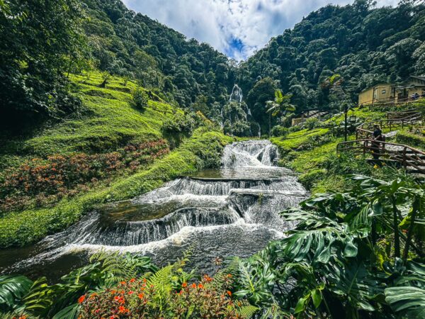 Lush green hills and cascading waterfalls blend harmoniously at Termales de Santa Rosa, Risaralda, Colombia.