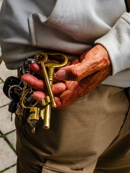 Rustic keys held in an older hand, showcasing texture and warmth, set against a soft backdrop in Quindio, Colombia.