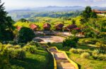 Vibrant green hills with a scenic pathway lead to rustic wooden structures at Mirador Colina Iluminada, Filandia, Quindio, Colombia.