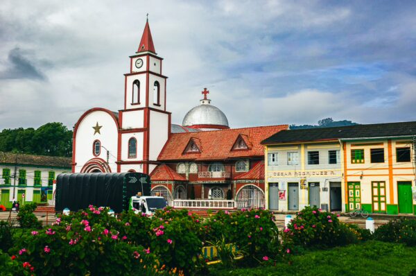Colorful buildings and the striking church with a red and white facade stand out in Milagrosa, Murillo, Tolima, Colombia.