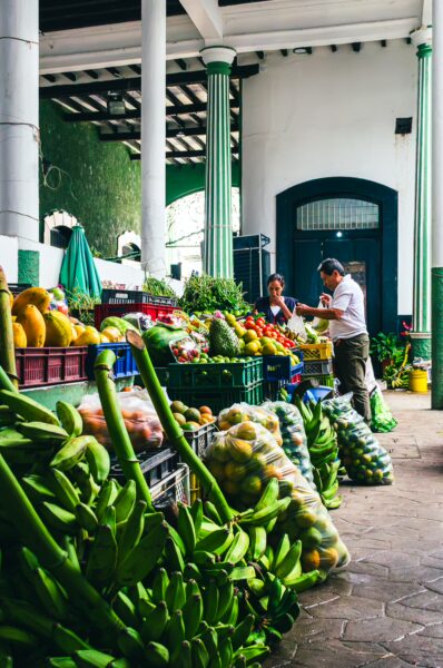 Vibrant stalls filled with fresh fruits and vegetables at Plaza de Mercado in Honda, Tolima, Colombia, create a lively marketplace atmosphere.