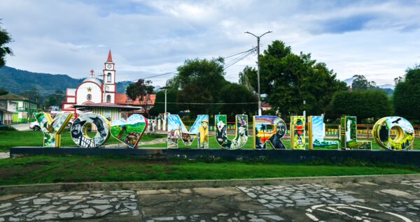 Colorful "Yo <3 Murillo" sign in Parque Principal Murillo, featuring vibrant colors and the backdrop of local architecture in Tolima, Colombia.