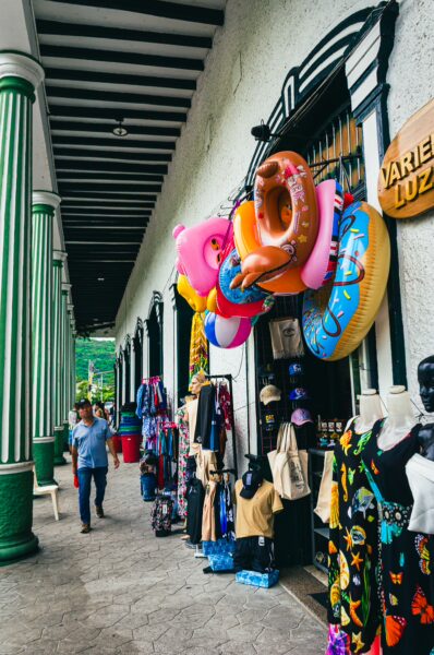 Vibrant market scene in Plaza de Mercado, Honda, Tolima, showcasing colorful swim rings and local clothing stalls.