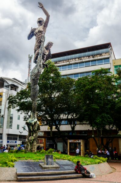 Monumento al Esfuerzo stands tall in Armenia, Quindío, showcasing striking bronze figures amidst green landscaping and urban backdrop.