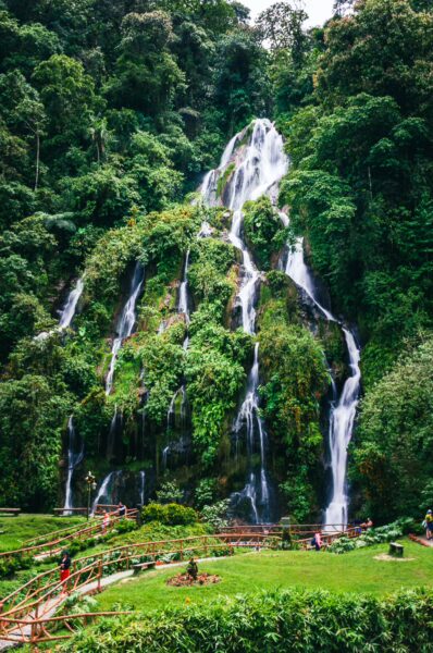 Lush greenery surrounds cascading waterfalls at Termales Rosa in Risaralda, Colombia, creating a serene natural oasis.