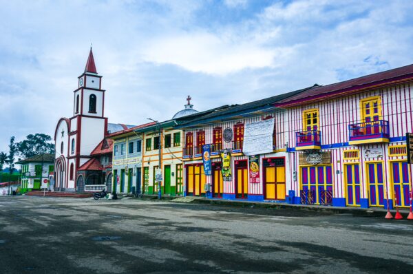 Colorful colonial buildings line the street in Murillo, Tolima, Colombia, showcasing vibrant hues and charming architecture.